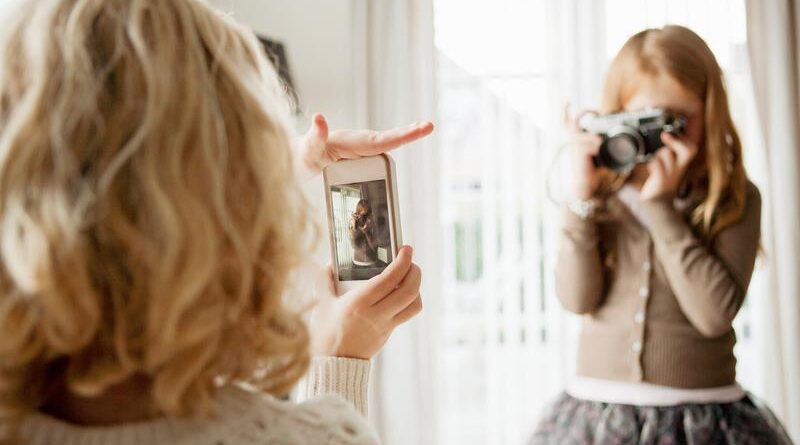 Niña tomando fotos con cámara análogica