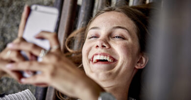 Persona sonriendo viendo celular